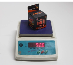 Detailed view of the 3x3 speed cube being weighed on a scale showing 72.6g weight