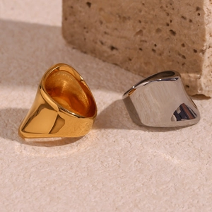 Detailed view of irregular geometric 18K gold and silver stainless steel rings on stone