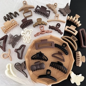 Detail view of plush hair claw clips in various shapes like butterfly and teddy bear