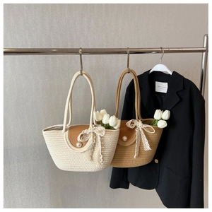 Detail of woven straw tote bags in beige and khaki with leather flaps and pearl buckles