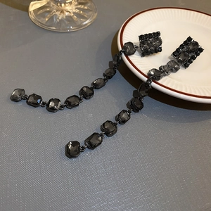 Close-up of black geometric crystal drop earrings with vintage long tassel design