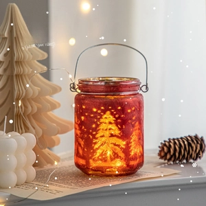 Red frosted glass Christmas lantern with glowing tree pattern and silver metal handle