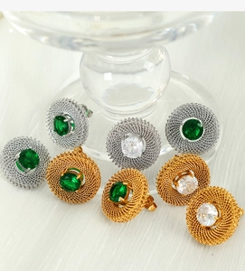 Detail of vintage woven mesh metal earrings with emerald and clear round gemstones
