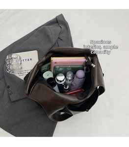 Top-down view of a spacious brown PU leather tote bag containing a tablet and daily items