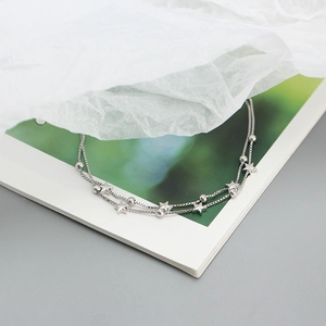 Elegant s925 silver double layer star bead bracelet displayed on a green vintage book