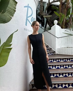 Detail of black sleeveless bodycon dress with front buttons and stylish high slit