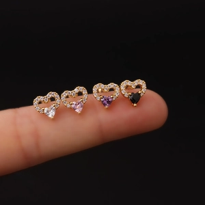 Detailed view of titanium steel heart studs with colorful zircons worn on fingers