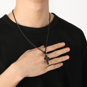 Close-up of black stainless steel cross pendant with diamond on twisted rope chain