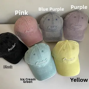 Detail view of six colorful washed cotton baseball caps with embroidered letter patches