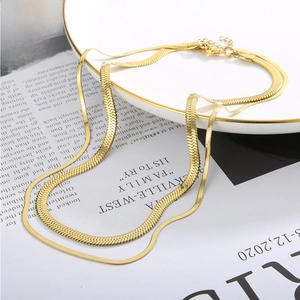 Detail of 18k gold plated flat snake chain double layer necklace with lobster clasp