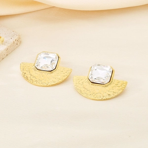 Dettaglio di orecchini a ventaglio in oro 18K con metallo martellato e pietra zircone