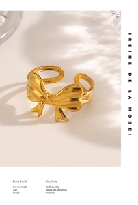 Macro view of 18K gold plated bow ring with dual-line band and polished finish