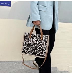 Lifestyle view of leopard print tote bag with brown straps styled with a casual blazer