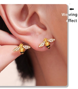 Wearing effect showing a golden bee earring with black stripes and sparkling zircon wings