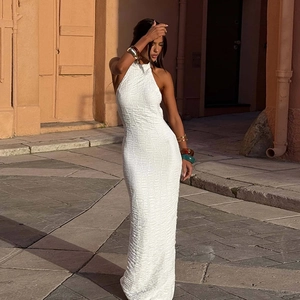 Detailed view of the white textured fabric on a backless halter midi dress for summer