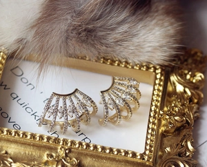 Macro shot of gold fan-shaped ear cuffs with marquise-cut zircons on a vintage frame