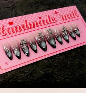 Détail macro de faux ongles gothiques faits main avec croix argentées et étoiles