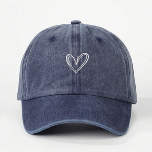Detail of blue washed denim baseball cap with white embroidered double hearts logo