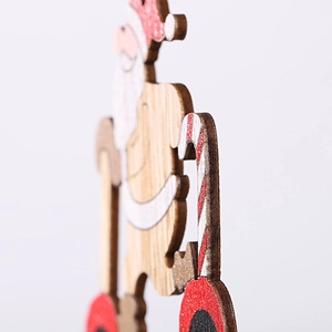 Detail of handcrafted wooden Santa figurine with candy cane and smooth painted finish