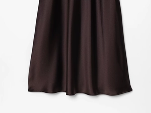 Detail of chocolate brown satin midi dress showing silky fabric texture and drape