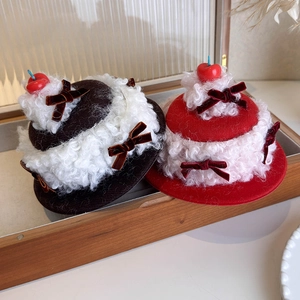 Close-up of velvet cherry cake hair clips with plush faux fur and ribbon details