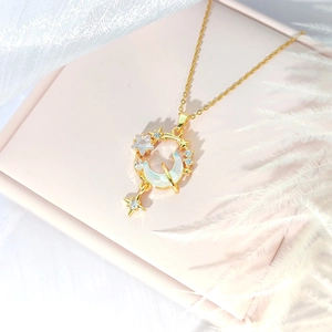 Elegant gold star and moon necklace with mother of pearl inlay on soft pink jewelry box