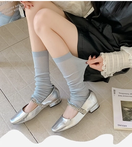 Detailed view of silver Mary Jane flats with crystal straps and light blue ribbed socks
