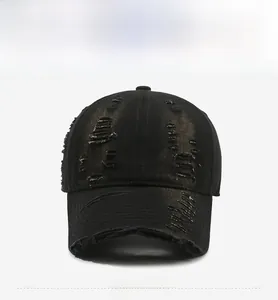 Detailed view of heavy distressed frayed holes with copper underlay on black baseball cap