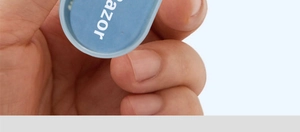 Close-up of blue dual-head nose hair trimmer tool with azor logo in a hand grip