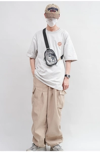 Male model wearing transparent PVC crossbody bag with black strap in studio setting