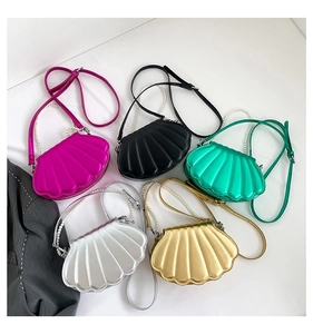 Detailansicht der muschelförmigen Umhängetaschen mit Perlenriemen in fünf Metallic-Farben