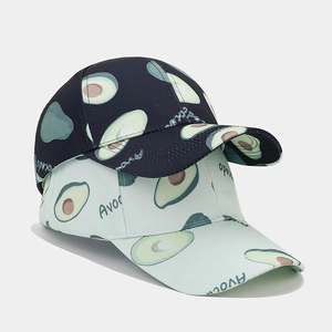 Detail of navy and light green baseball caps with avocado print and cotton texture