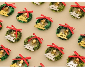Miniature Christmas wreaths with red bows, gold bells, and Merry Christmas signs