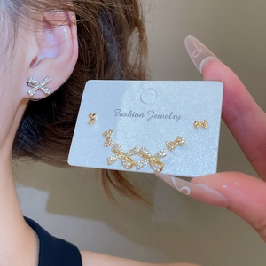 Detailed view of 18k gold plated bowknot earring set with zircon on model's ear