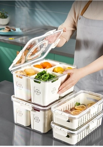 Close-up of clear food storage box with white drain basket and silicone sealing ring lid
