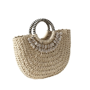 Handmade woven straw shell bag with striped handles for summer beach vacation style