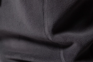 Macro shot of dark grey polar fleece fabric texture with reinforced stitching detail