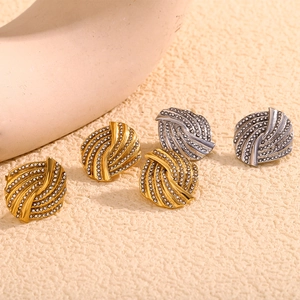 Detailed view of 18K gold and silver plated spiral stud earrings with pave crystals