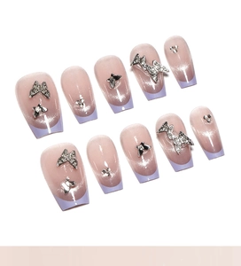 Close-up of lilac cat-eye press-on nails with 3D silver butterfly and rhinestone details