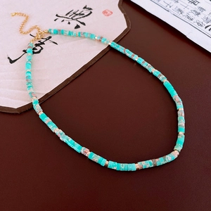 Detail view of retro beaded necklace with turquoise-style stones and golden metal spacers