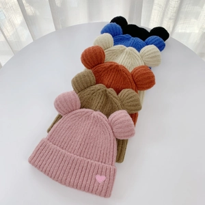 Detail view of knitted beanies with bear ears and heart patches in six colors