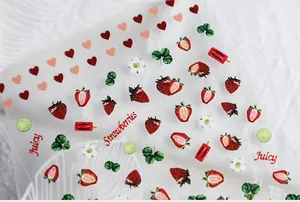 Macro view of strawberry and heart nail stickers with clear printing details on white fabric