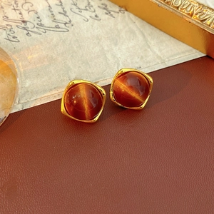 Vue détaillée de boucles d'oreilles vintage en résine marron avec bords dorés et effet brillant