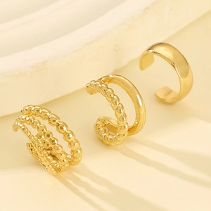 Three-piece gold ear cuff set with smooth, twisted, and beaded textures on stone