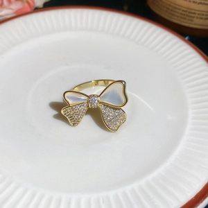 Macro shot of 14k gold bow ring with mother of pearl and cubic zirconia stones
