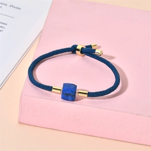 Détail du bracelet en corde tressée bleue avec perles de lapis-lazuli et fermoir en or