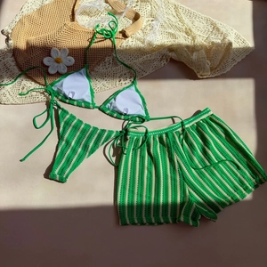 Detailed macro view of the handmade crochet texture on green striped three-piece bikini set