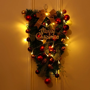 Leuchtender weihnachtlicher Türkranz mit roten Kugeln und goldener Juteschleife