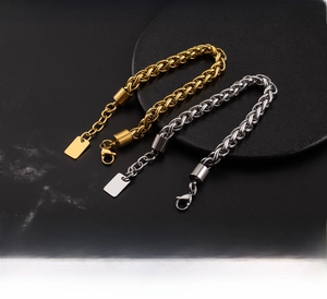 Detail of chunky stainless steel basket chain bracelet with lobster clasp and logo tag