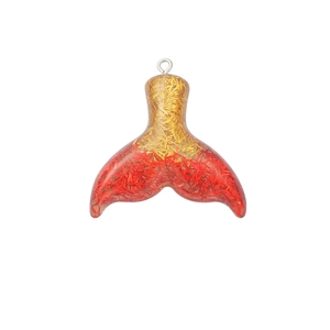 Close-up of a gradient resin mermaid tail pendant with gold and red glitter accents